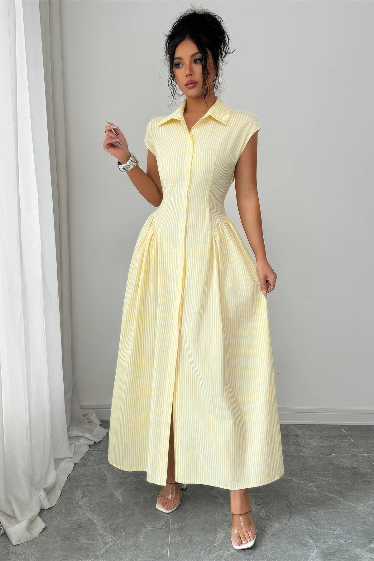 Robe longue jaune à encolure chemise, manches courtes, taille froncée, jupe évasée.