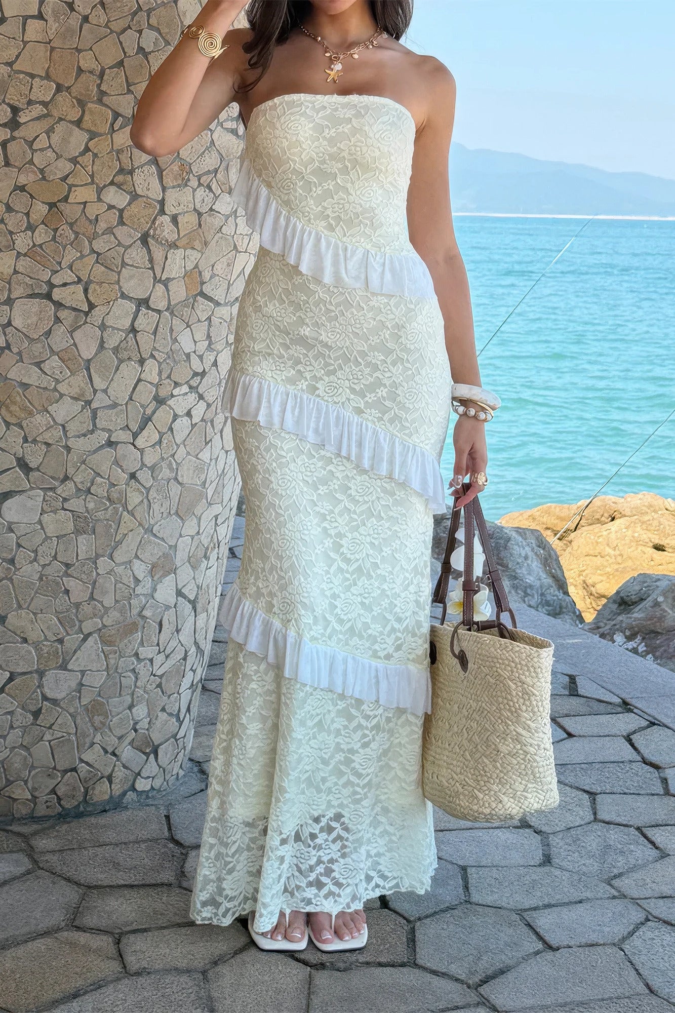 Robe maxi dentelle blanche bustier sans bretelles, volants en cascade sur la jupe.