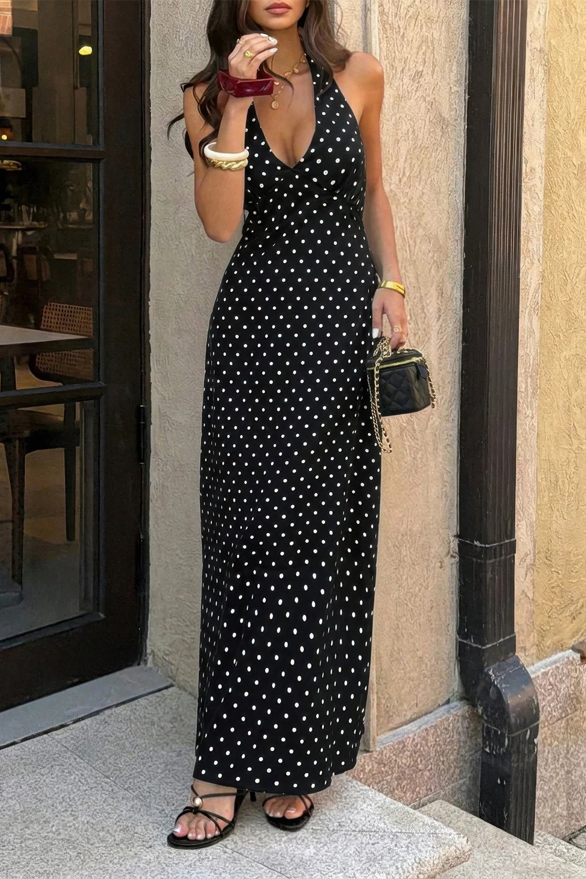 Robe longue noire à pois blancs, bretelles fines, dos et encolure plongeante visibles.