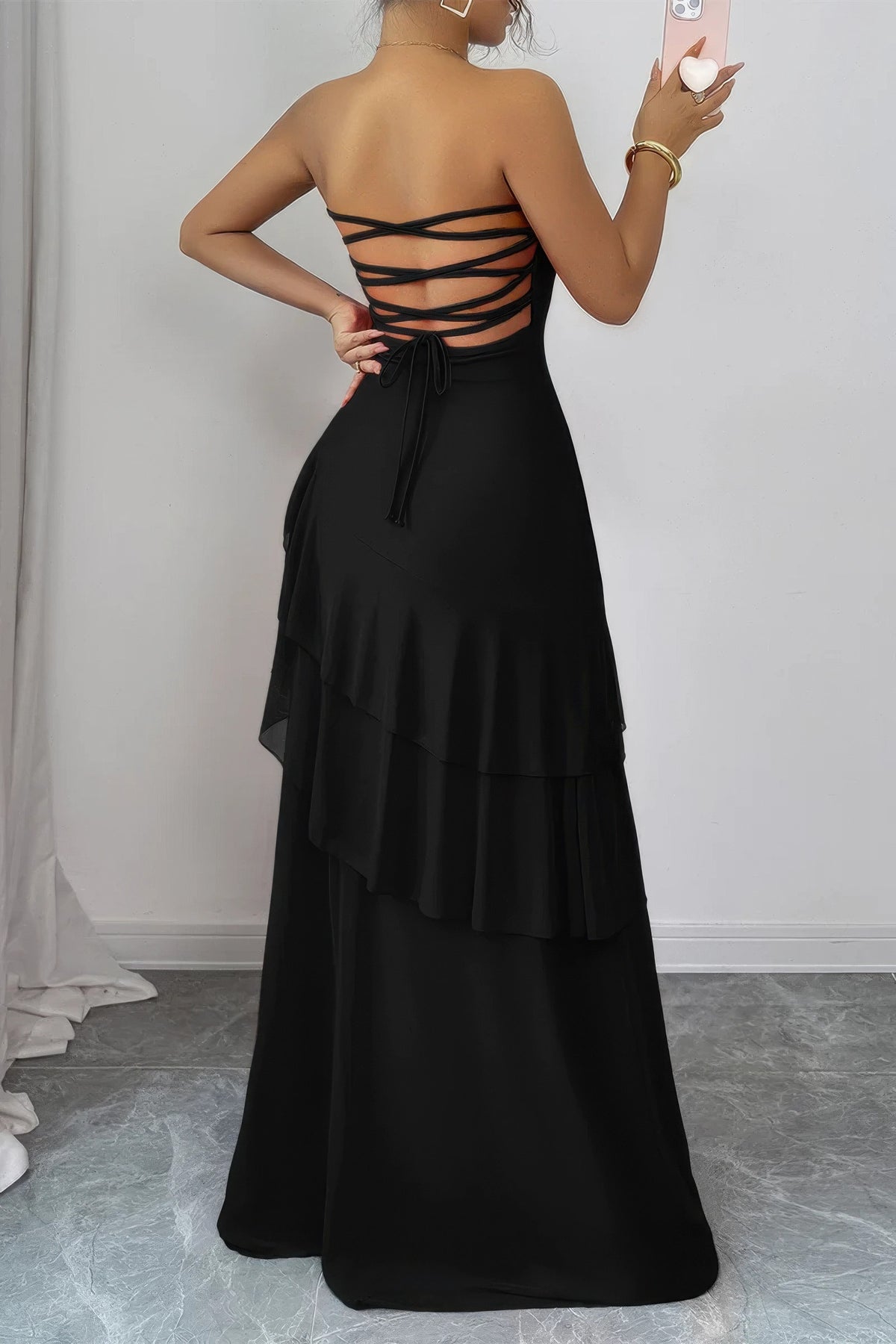 Robe longue noire au dos croisé avec laçage, volants superposés, taille marquée