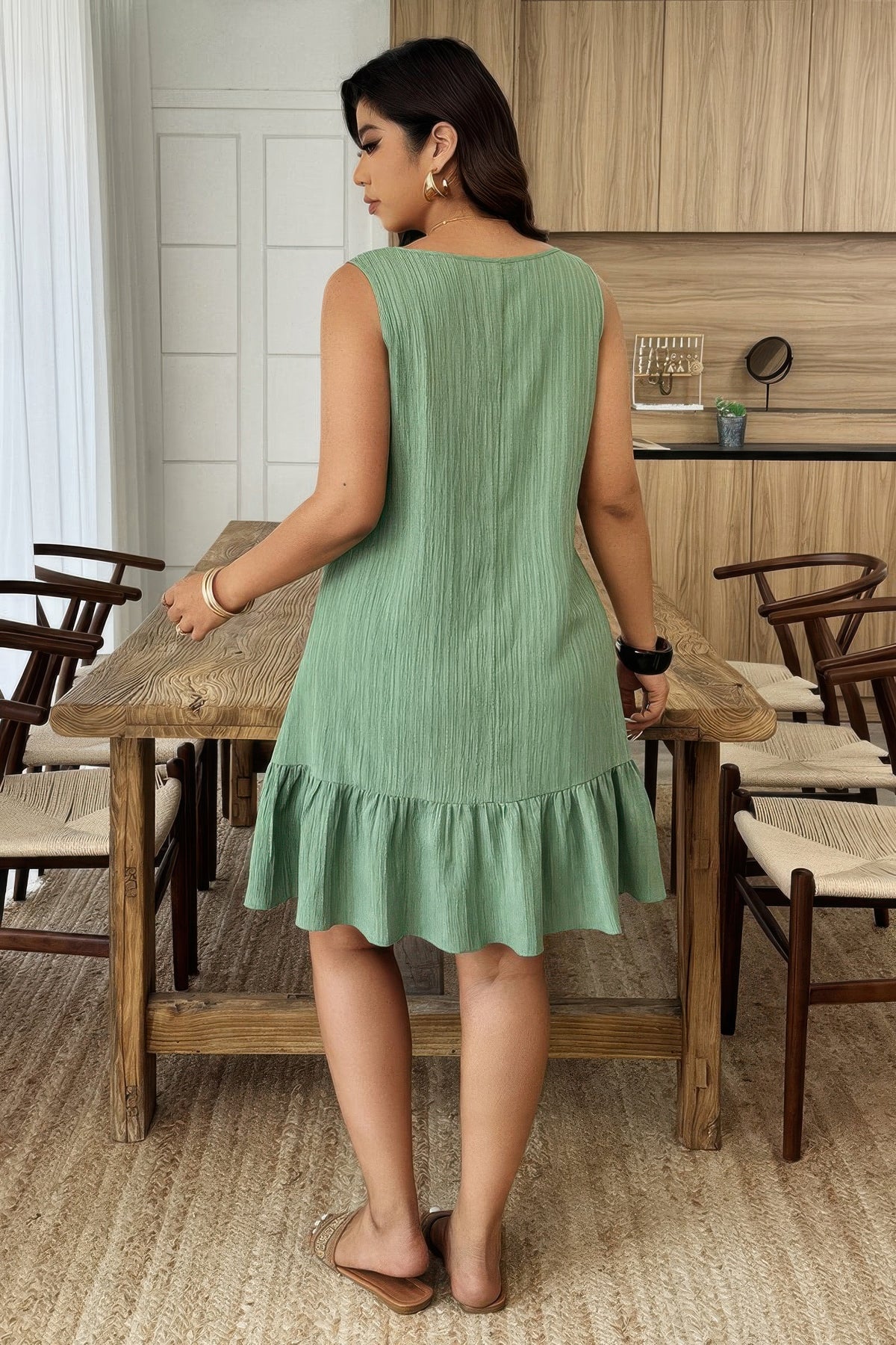 Robe verte sans manches, coupe évasée à volants au bas, vue de dos