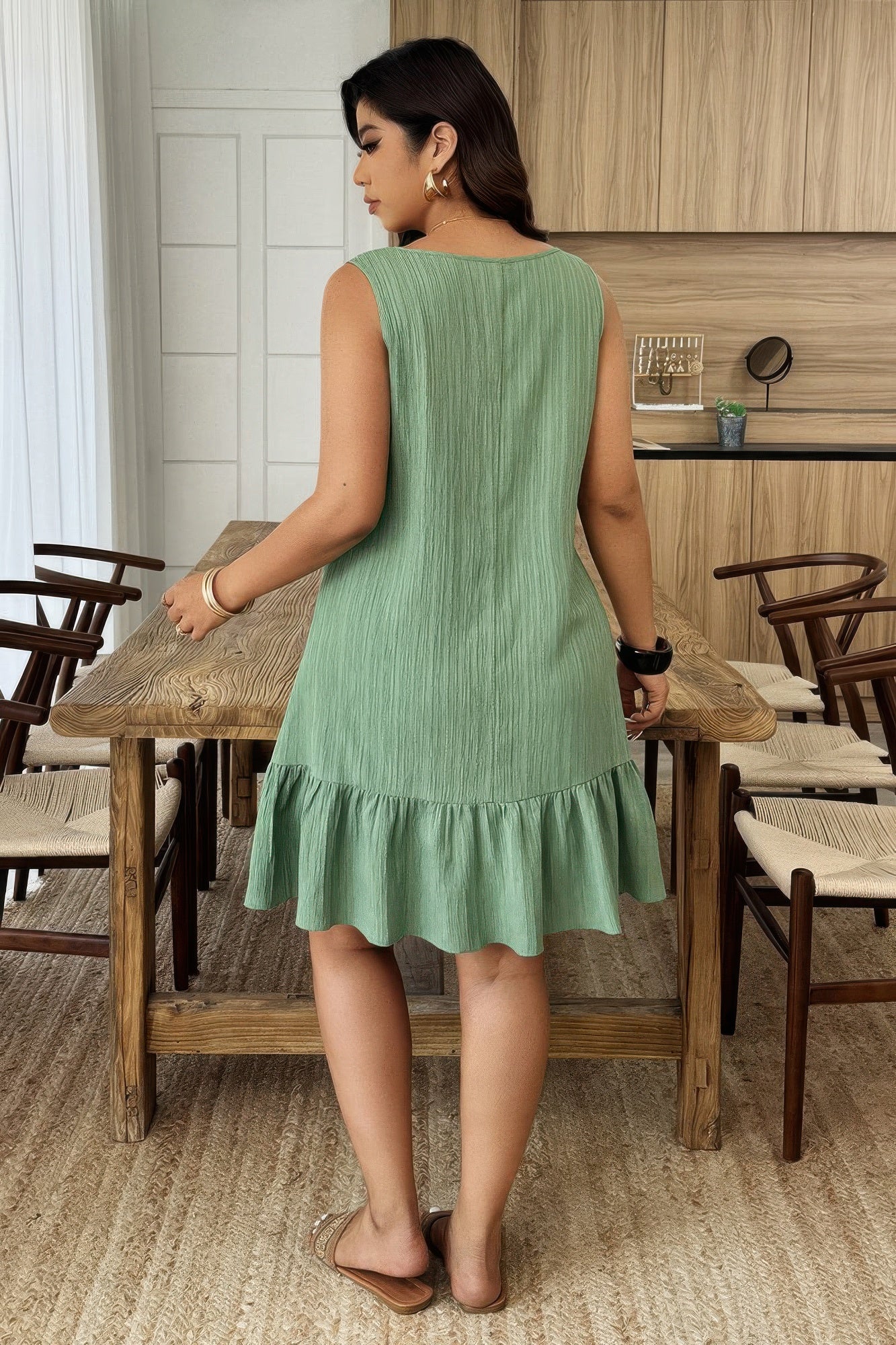 Robe verte sans manches, coupe évasée à volants au bas, vue de dos