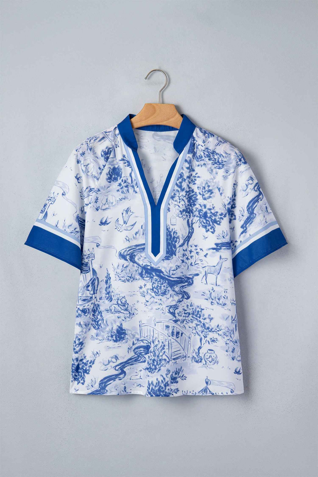 Haut femme col V contrasté, manches raglan, imprimé bleu sur fond clair, sur cintre.