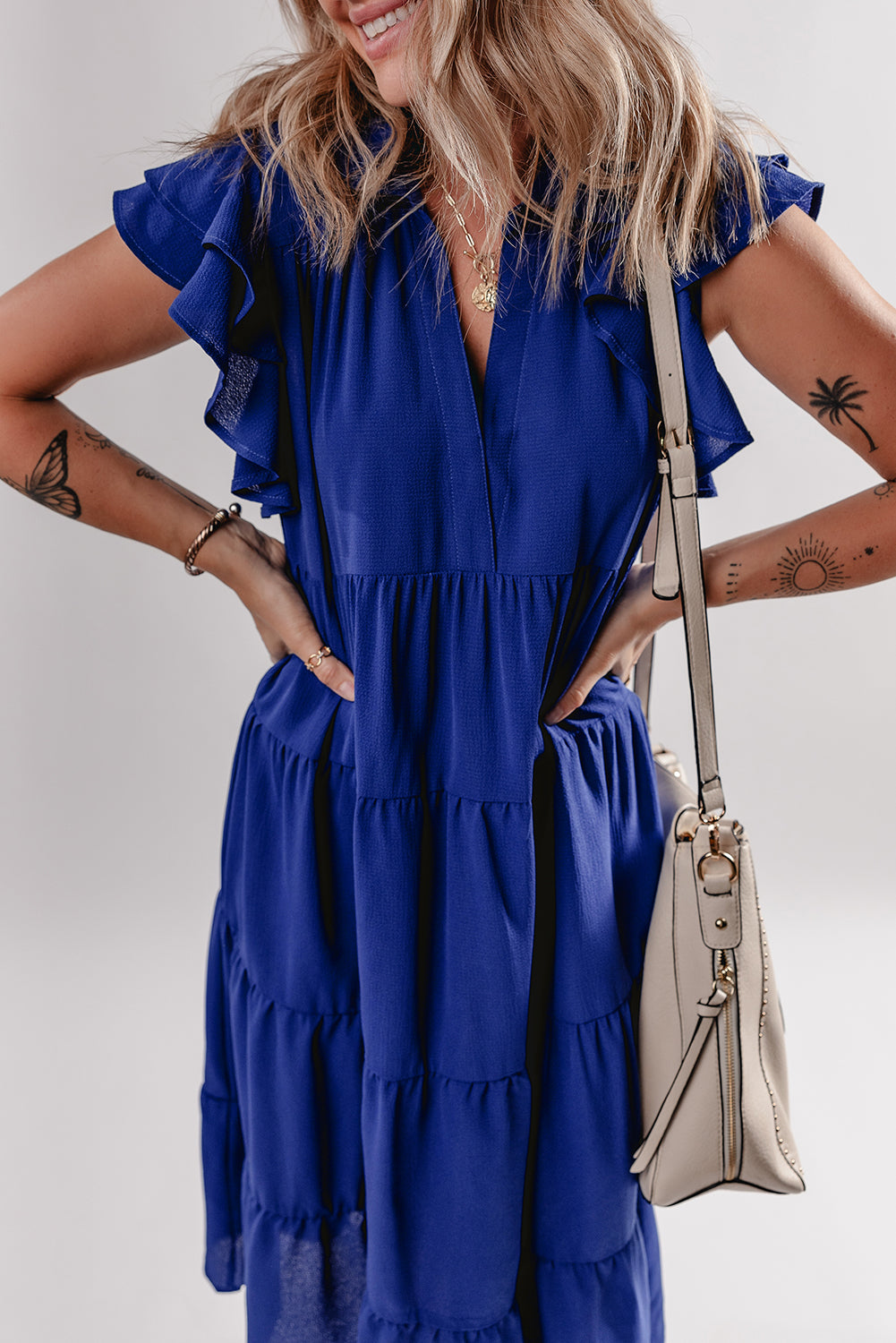 Robe midi bleue cintrée à volants, encolure V et manches volantées.