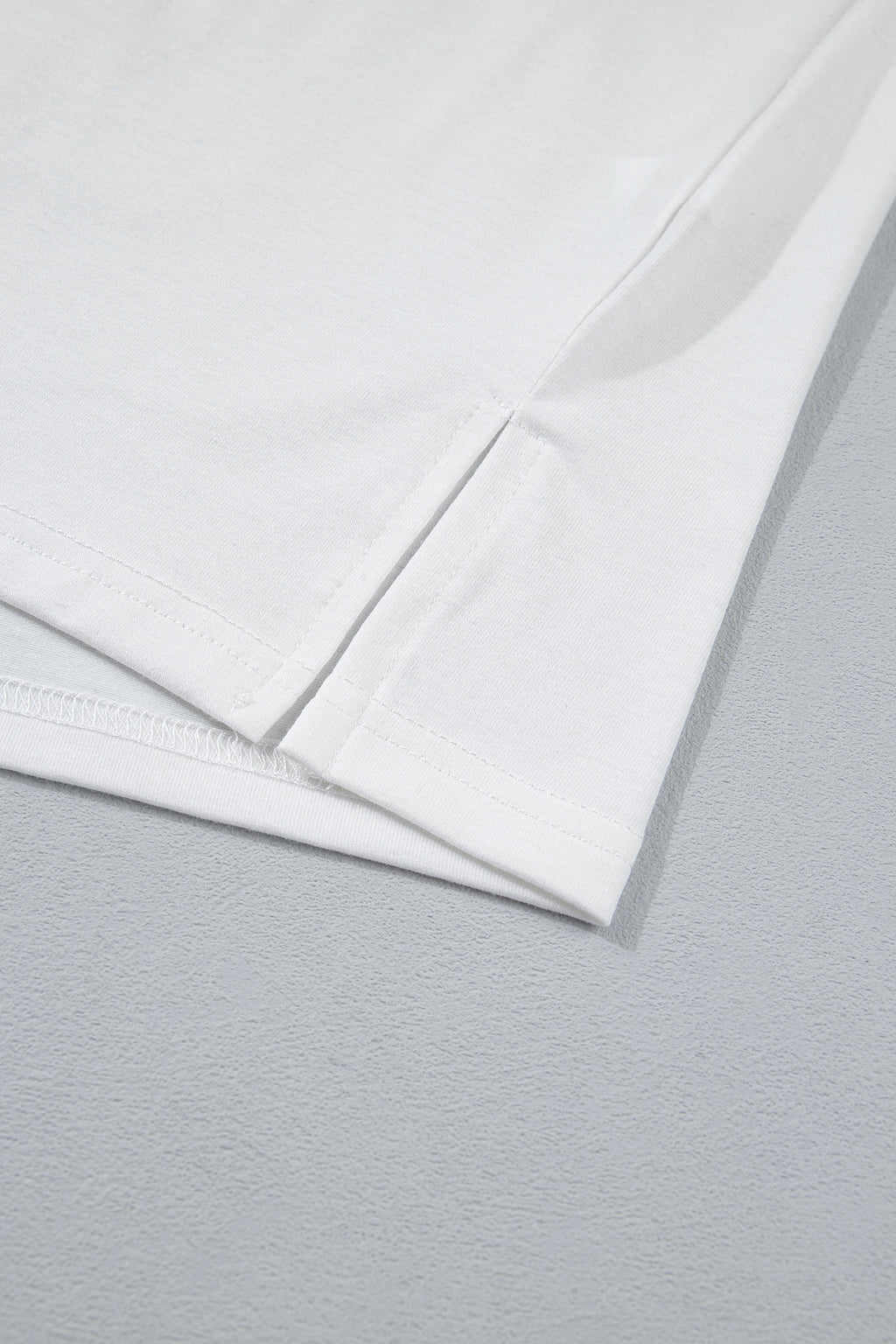 Ourlet et couture latérale du t-shirt blanc.