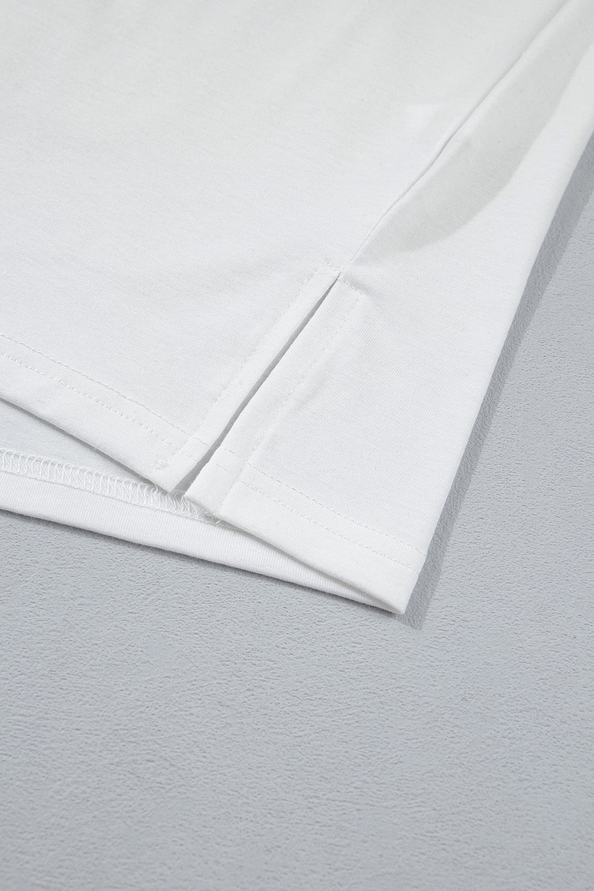 Ourlet et couture latérale du t-shirt blanc.