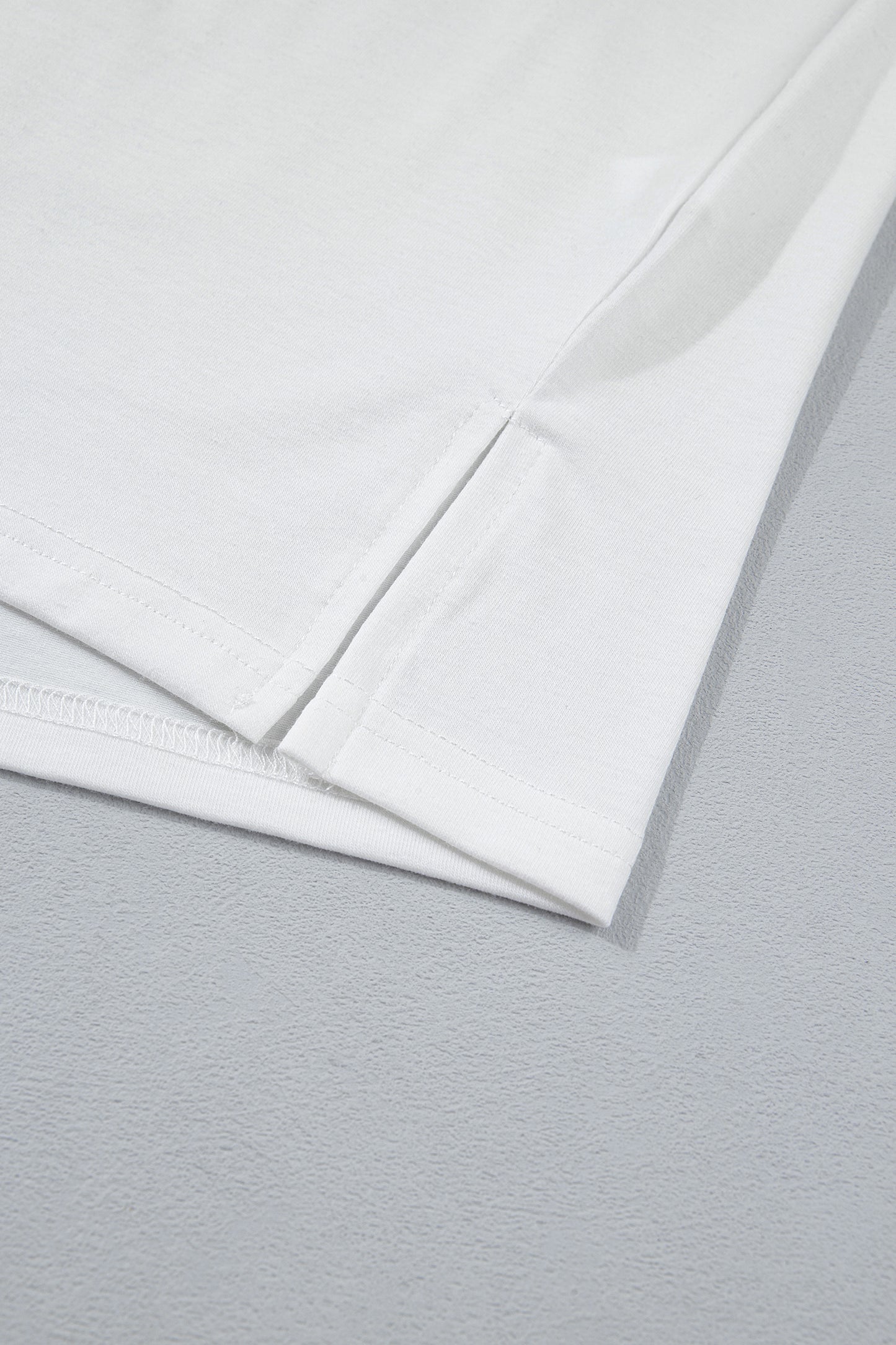 Ourlet et couture latérale du t-shirt blanc.