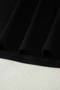 Haut polo bicolore en denim, ourlet bas noir et couture visible.