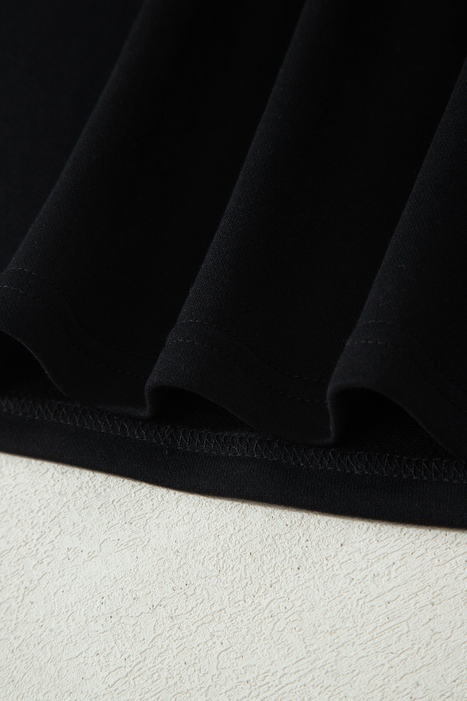 Haut polo bicolore en denim, ourlet bas noir et couture visible.