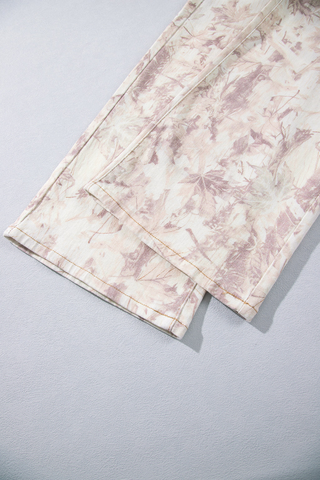 Jean large femme motif camouflage rose clair, ourlet et pli du bas de jambe.