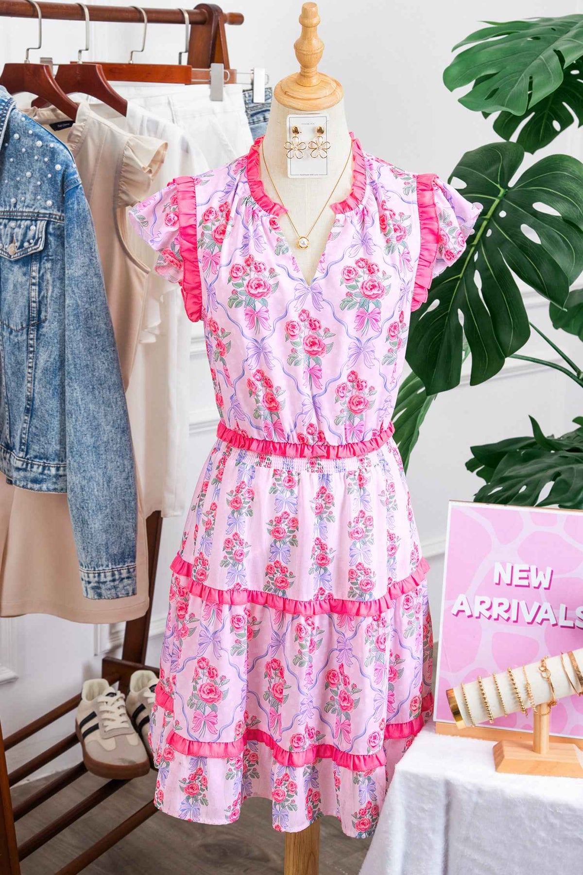 Robe fleurie sans manches à volants étagés, fond bleu clair, détails volant rose sur le col