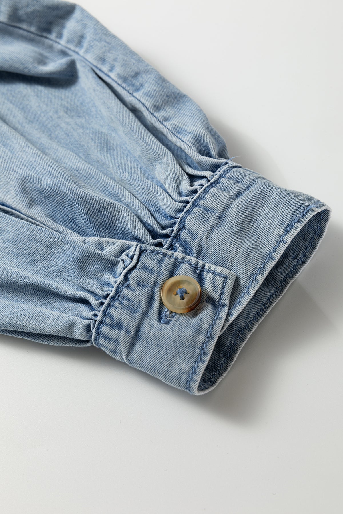 Poignet en jean bleu froncé avec bouton et surpiqûres