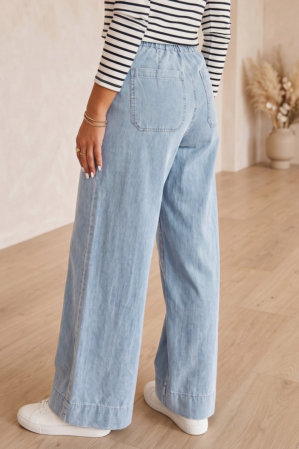 Jean en denim bleu clair à jambe ample, poche arrière visible, taille mi-haute