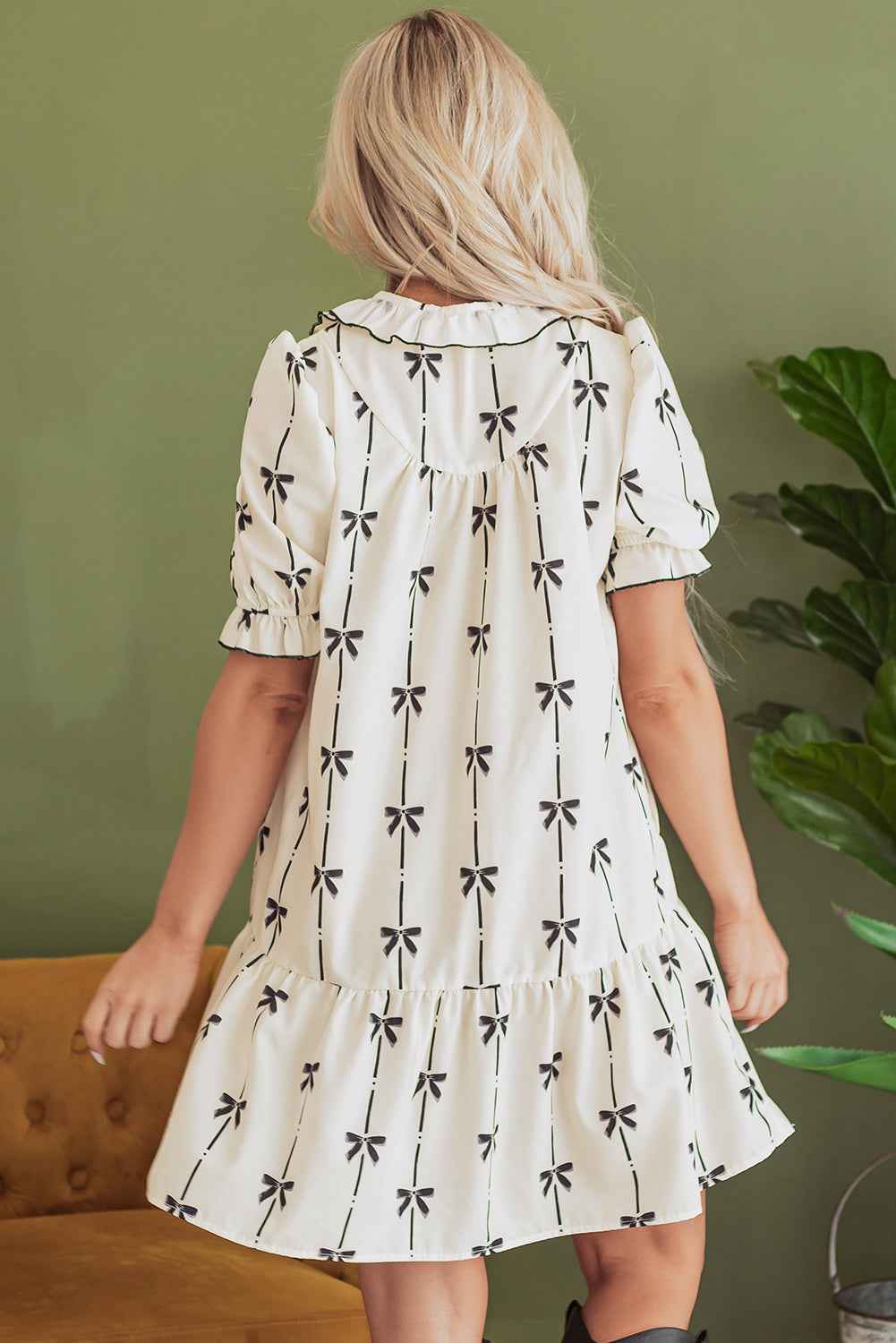 Robe courte crème à nœuds papillon, vue dos, manches bouffantes et volants.