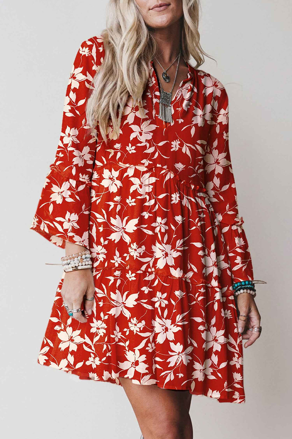 Robe mini rouge à fleurs blanches, manches 3/4 évasées, encolure boutonnée