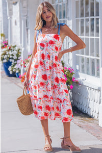 Robe midi à bretelles fines, imprimé floral rouge, nœuds bleus sur les épaules.