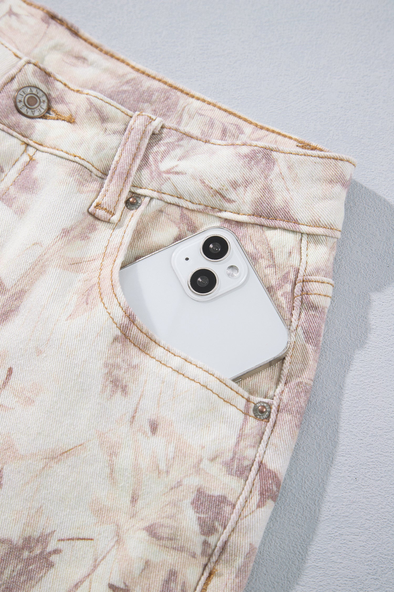 Jean large femme motif camouflage rose clair, bouton et fermeture à la taille.