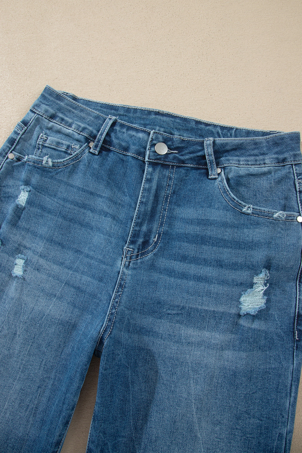 Jean taille haute en denim bleu moyen, poches et boutons, effet délavé