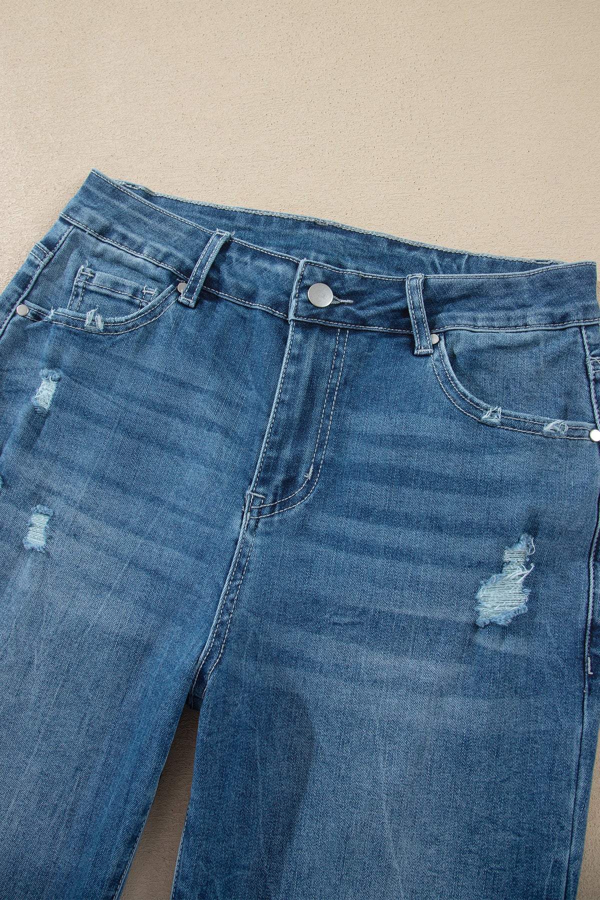 Jean taille haute en denim bleu moyen, poches et boutons, effet délavé