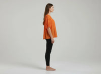 Haut femme orange, manches courtes bouffantes, vue de côté, encolure froncée