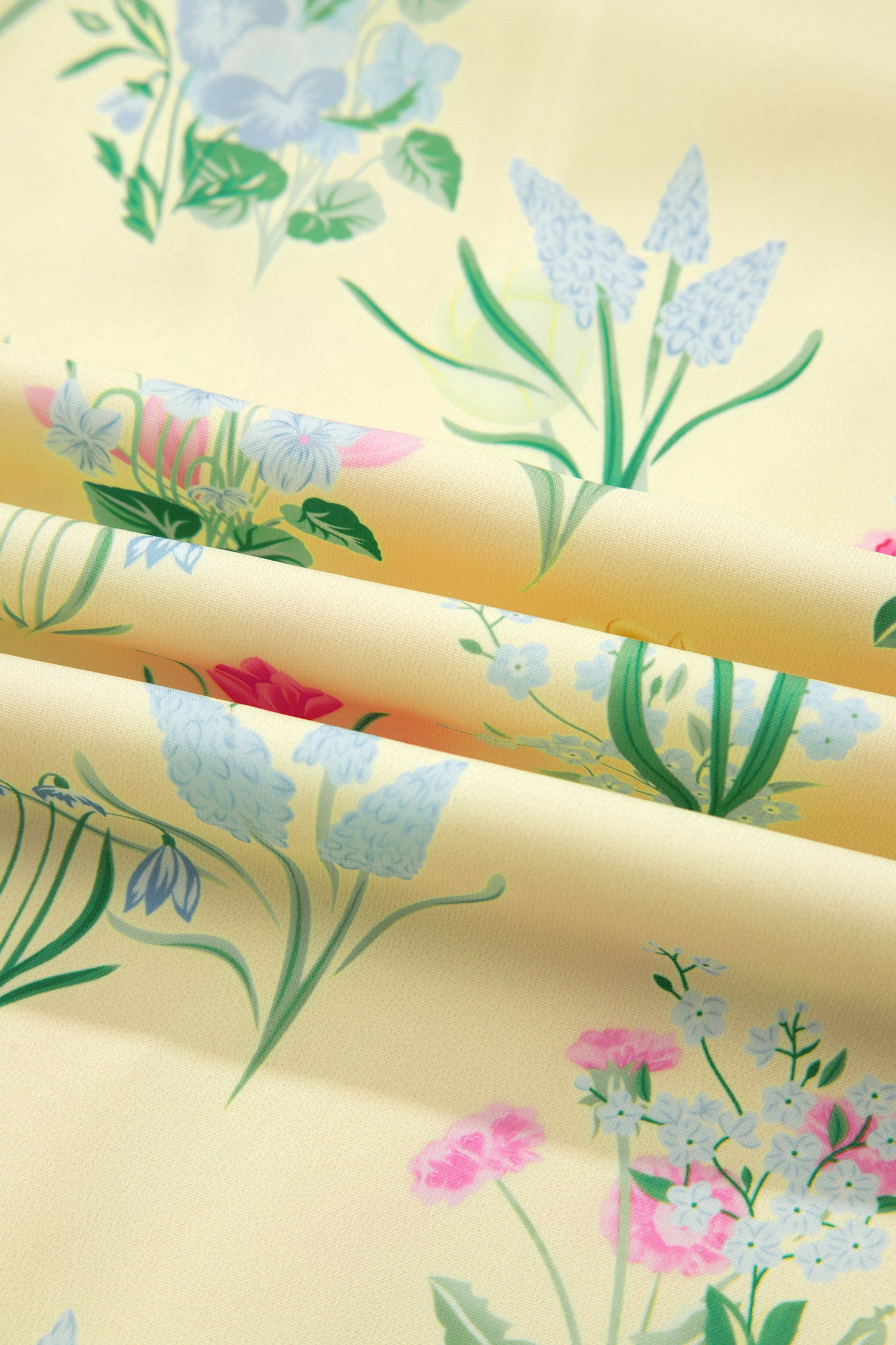 Tissu de robe crème à fleurs botaniques multicolores, verts, roses et bleus.