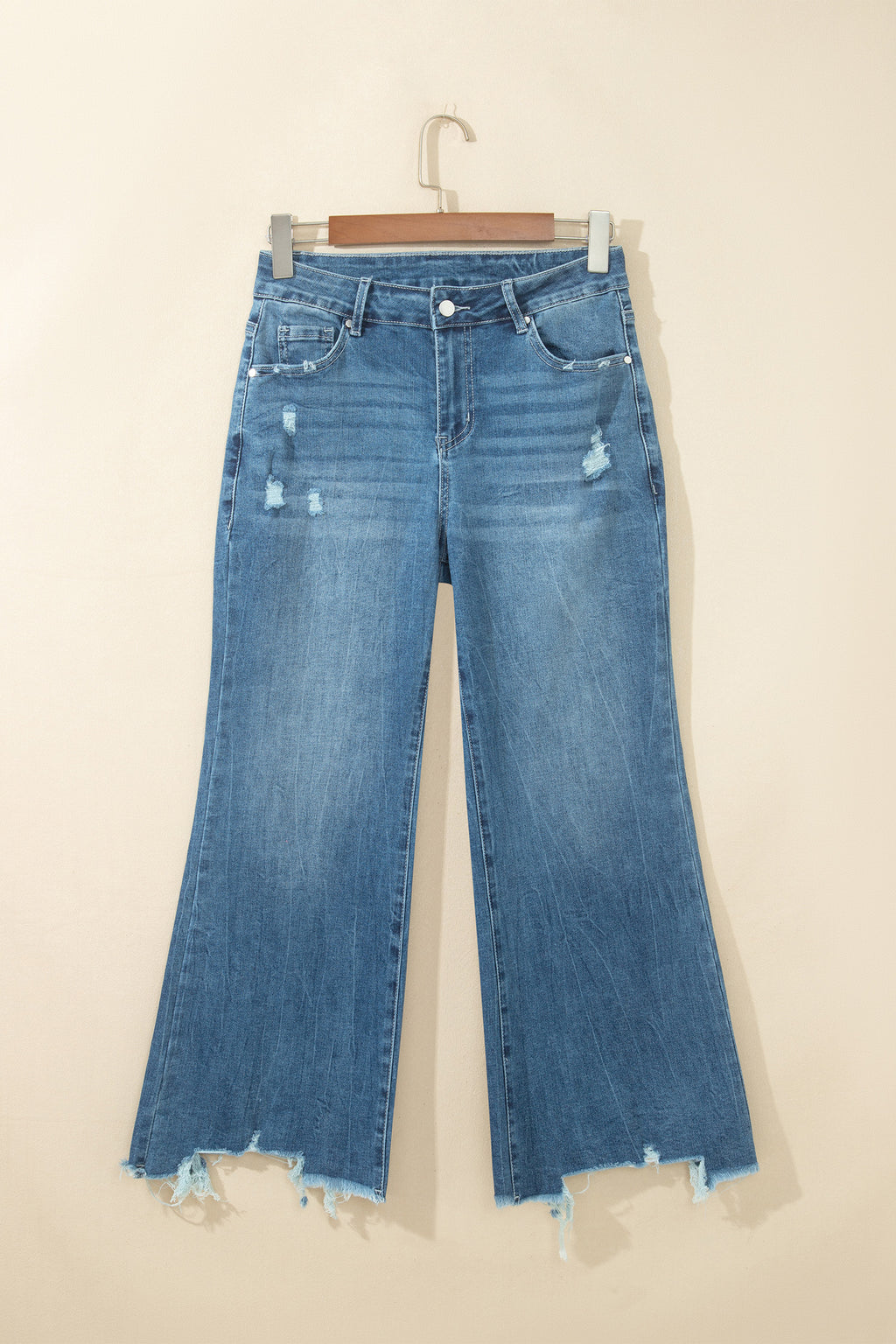 Jean flare taille haute bleu moyen, poches devant, ourlet effiloché et déchirures.