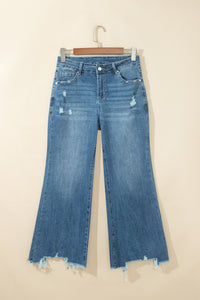 Jean flare taille haute bleu moyen, poches devant, ourlet effiloché et déchirures.
