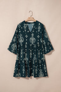 Robe mini verte foncée à motifs baroques clairs, manches trois-quarts, sur cintre