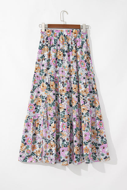 Jupe longue à imprimé floral bleu et multicolore, taille froncée et volants superposés.