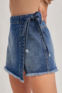 Short en jean bleu à ceinture nouée et poches à rabat, ourlet effiloché