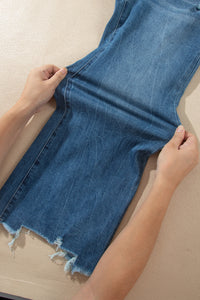Jean flare taille haute bleu moyen, vue de jambe avec ourlet effiloché.