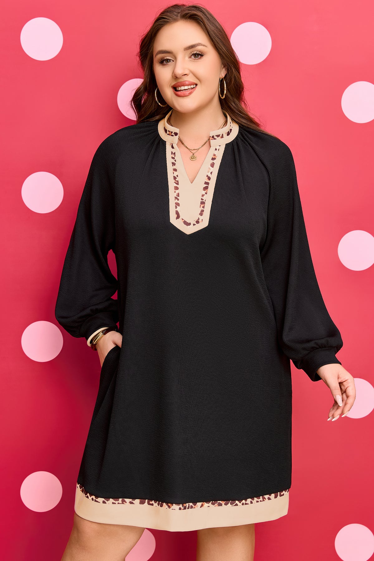 Robe mini noire, manches bouffantes, bordures léopard au col et à l’ourlet.