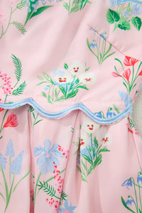 Robe rose à fleurs, volant ondulé avec bord bleu, plis froncés.