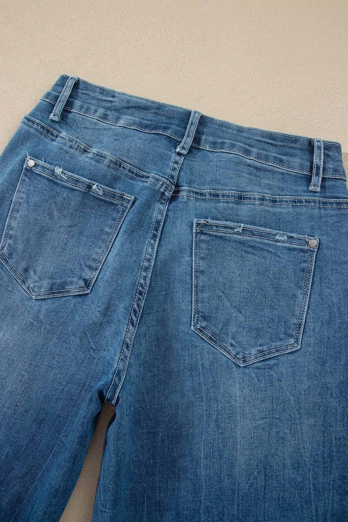 Jean flare taille haute bleu moyen, vue du dos avec poches et boutons.