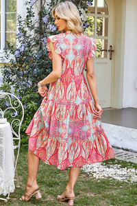 Robe mi-longue rose motif paisley, manches volantées, jupe évasée à volants.