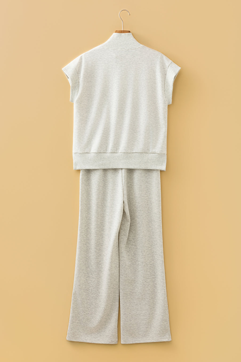 Ensemble polo zippé et pantalon large écru clair, vue arrière sur cintre