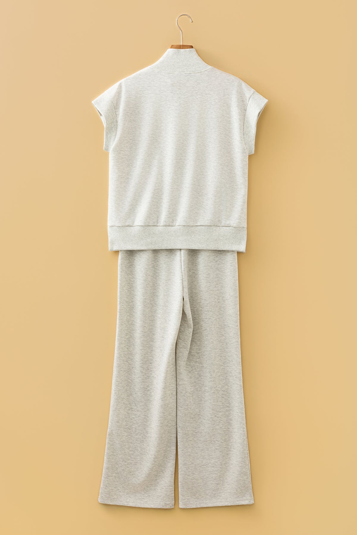Ensemble polo zippé et pantalon large écru clair, vue arrière sur cintre