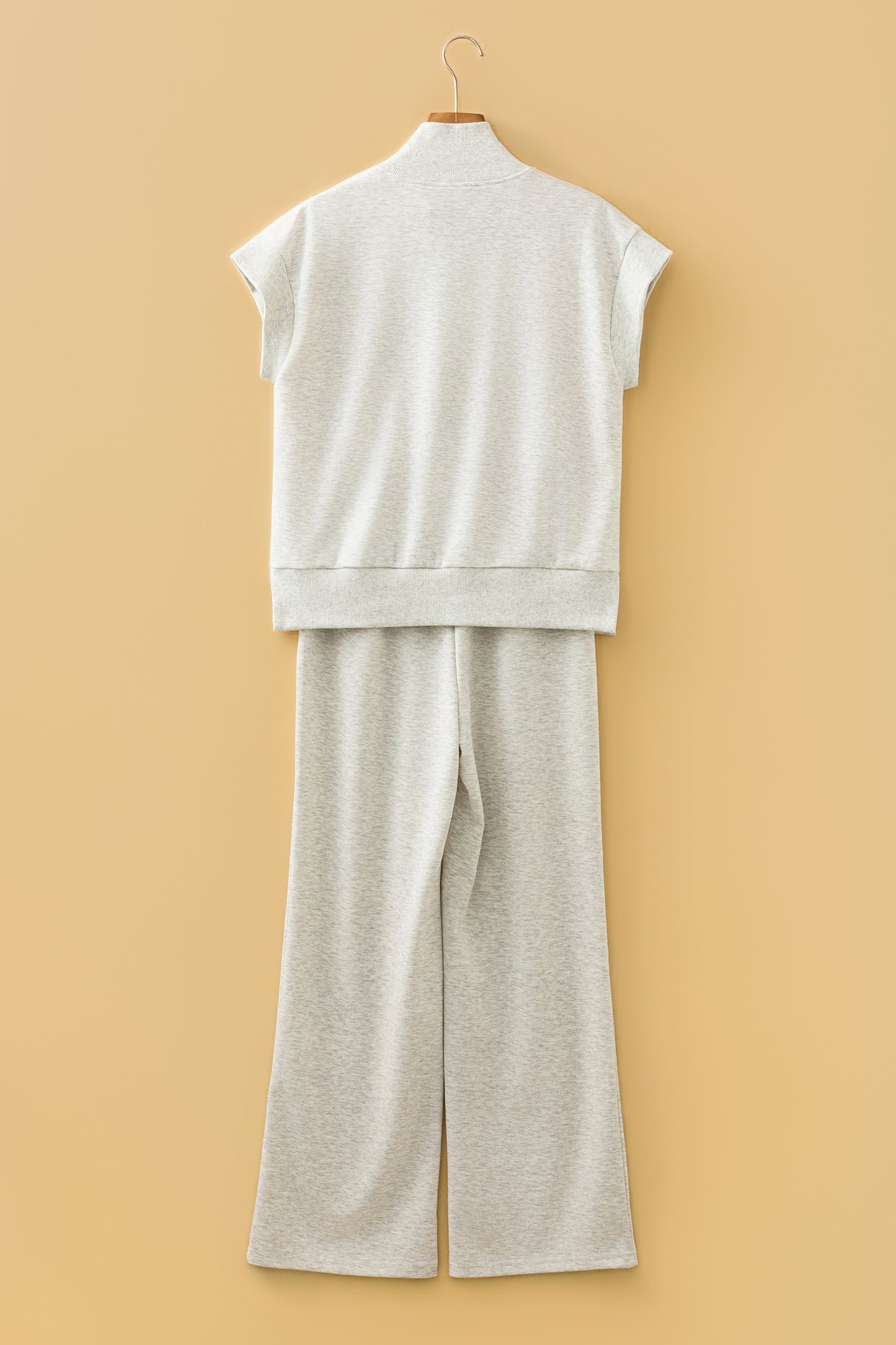 Ensemble polo zippé et pantalon large écru clair, vue arrière sur cintre