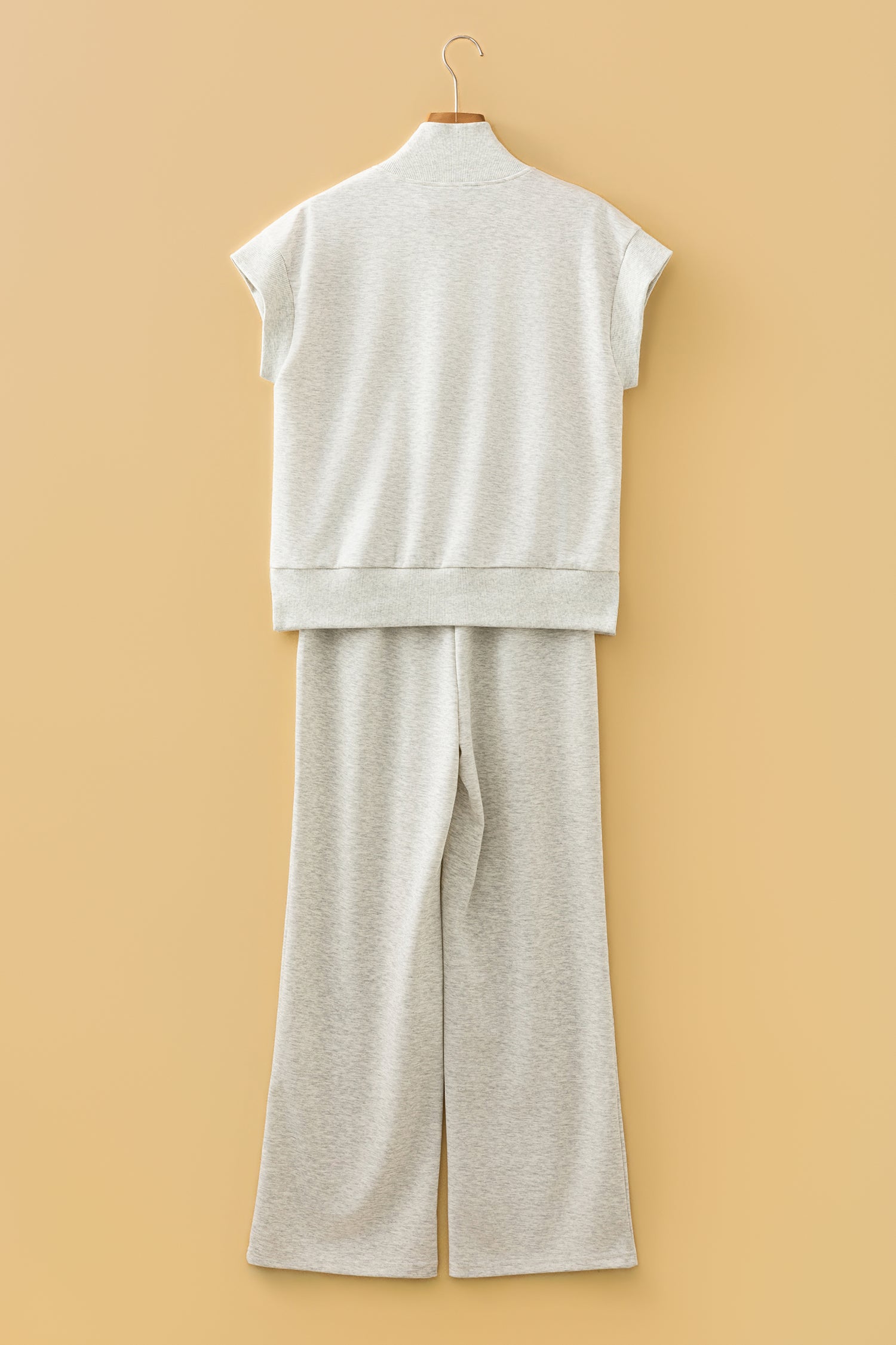 Ensemble polo zippé et pantalon large écru clair, vue arrière sur cintre