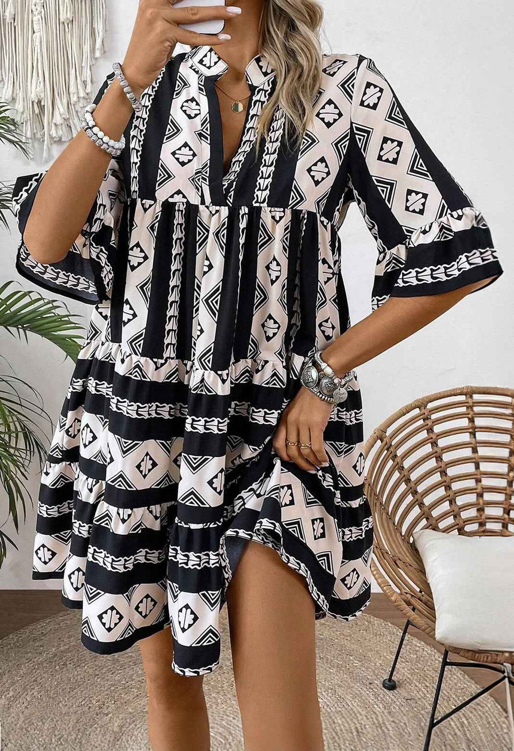 Robe noire motifs géométriques, col V, manches courtes à volants