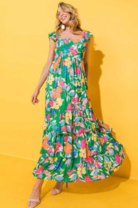 Robe longue verte à fleurs multicolores, haut volanté et jupe évasée ample.