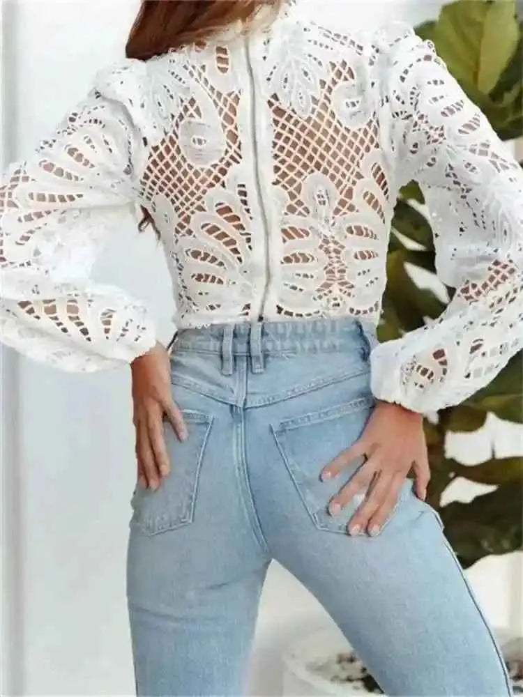 Chemisier dentelle blanche ajourée, manches bouffantes, porté avec jean bleu clair