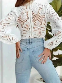 Chemisier dentelle blanche ajourée, manches bouffantes, porté avec jean bleu clair
