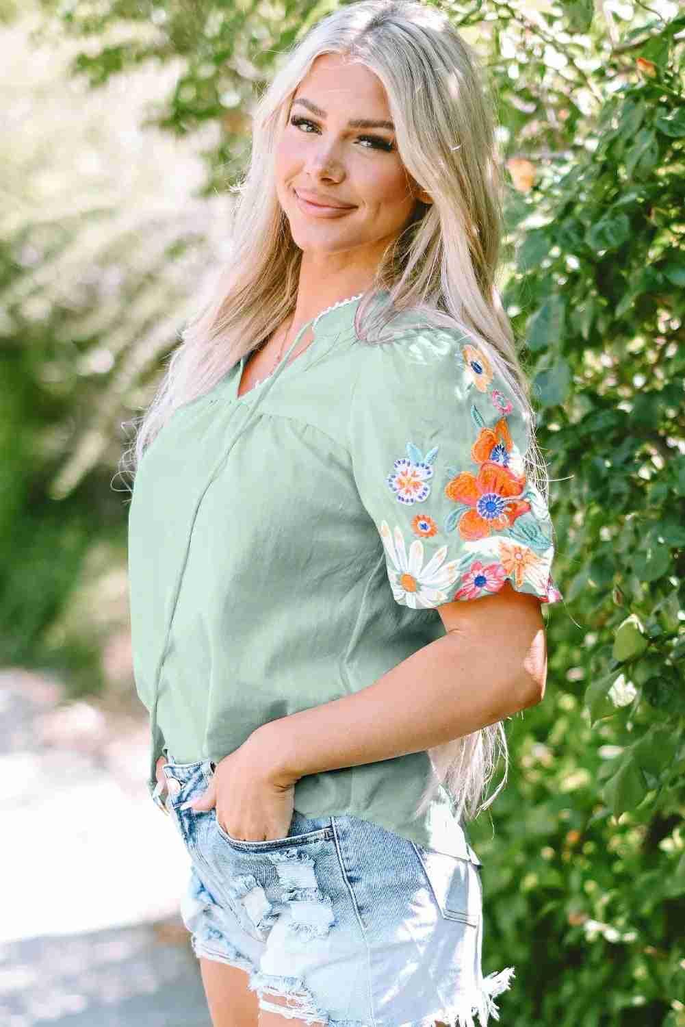 Chemisier femme vert clair brodé floral multicolore, manches courtes évasées.
