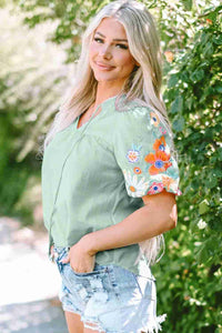 Chemisier femme vert clair brodé floral multicolore, manches courtes évasées.