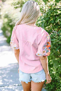 Chemisier femme rose à broderies florales multicolores au dos, manches bouffantes.