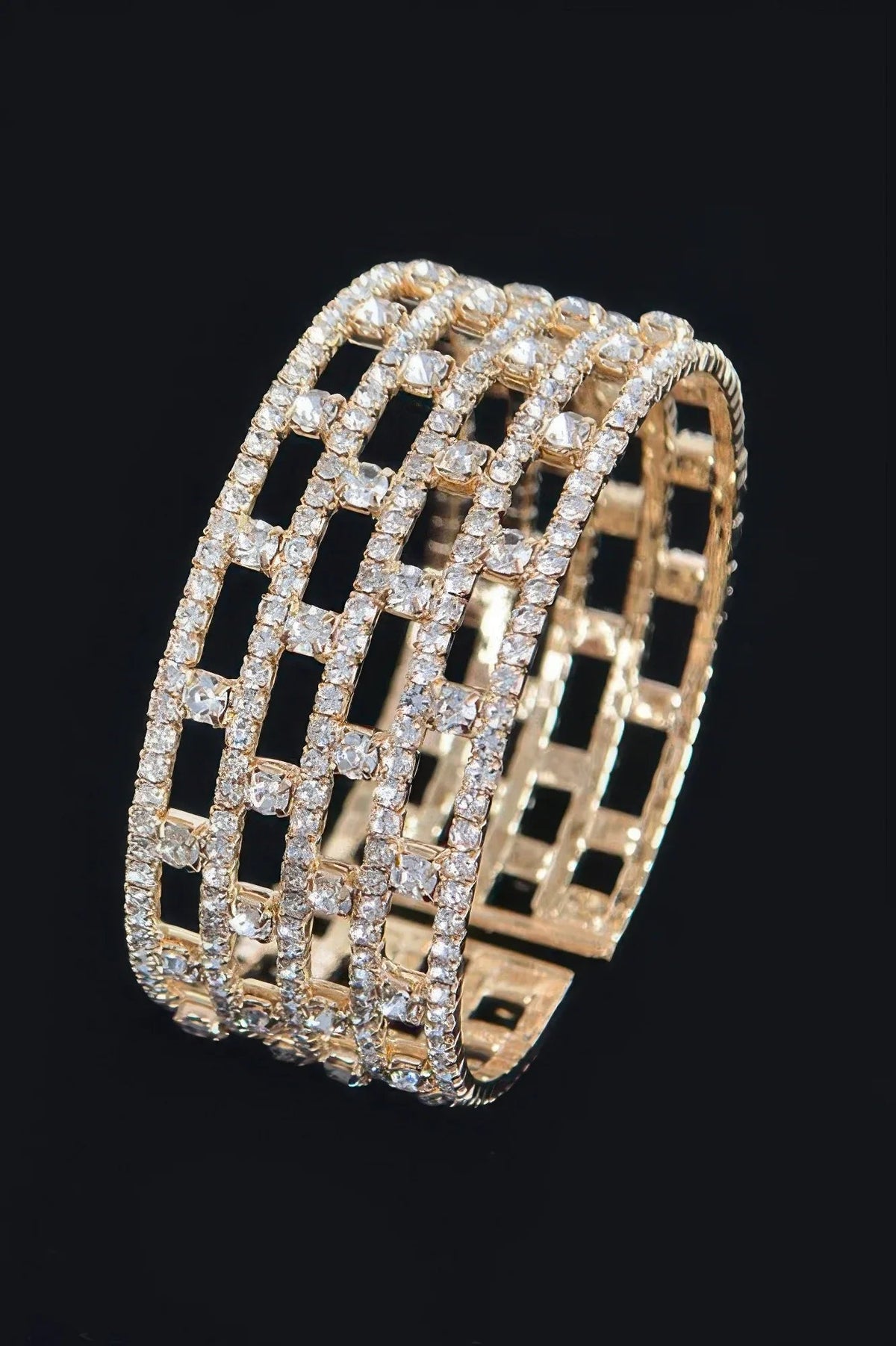 Jonc à strass motif grille, monture dorée, surface à carreaux.