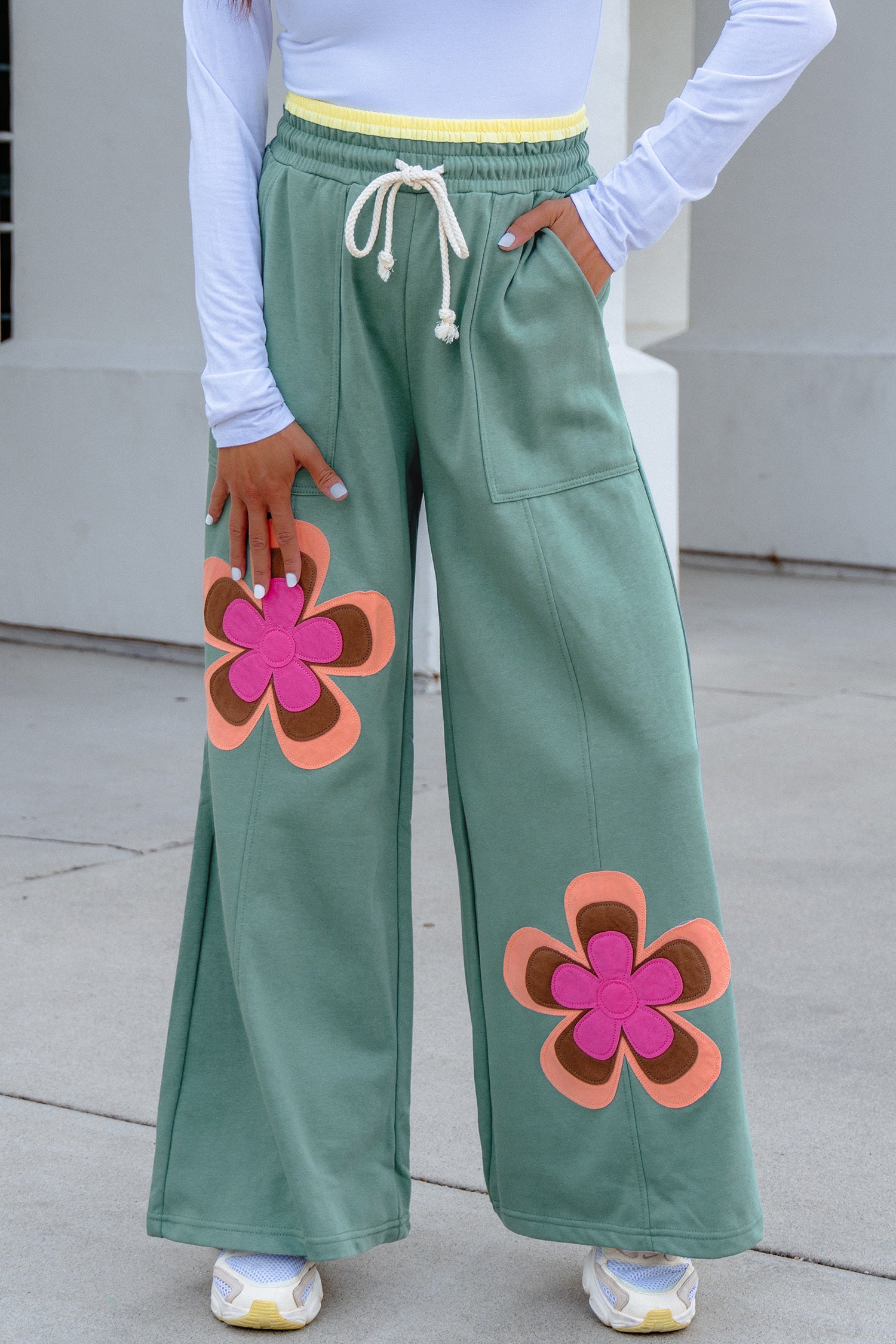 Pantalon ample vert mer à grands motifs floraux, cordon à la taille, poches latérales.