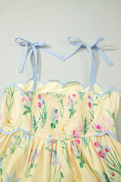 Haut de robe crème : bretelles nouées bleu clair, smock fleuri et ourlet festonné.
