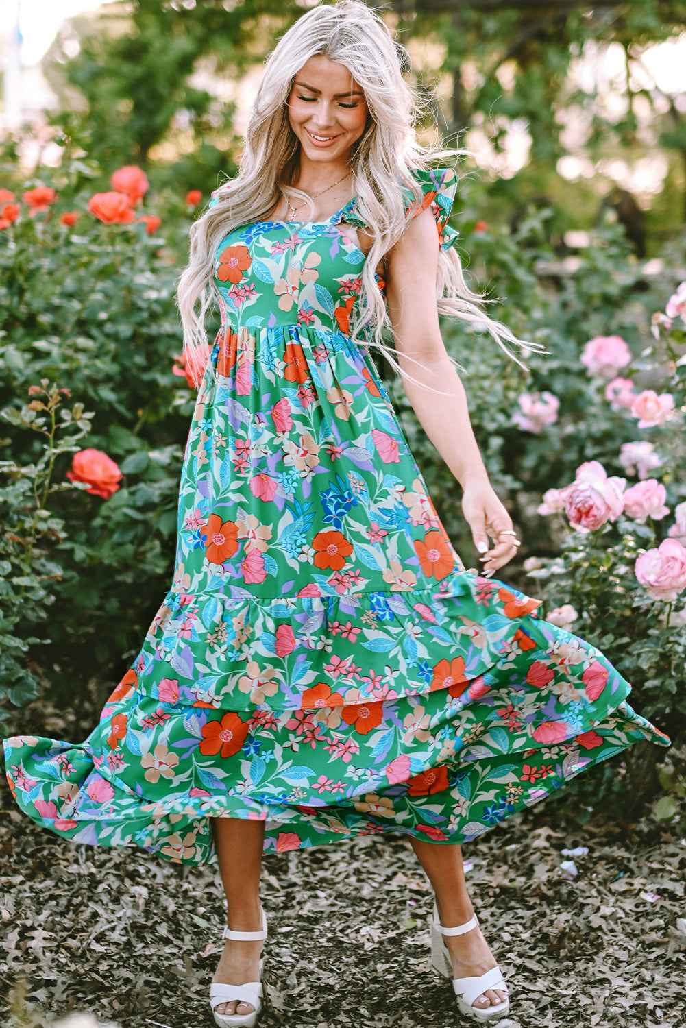 Robe longue verte à fleurs multicolores, bretelles volantées, jupe ample avec volants.